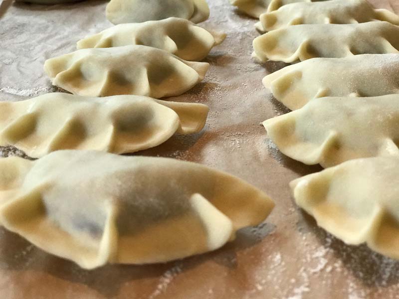 pierogies layed out on a board before cooking