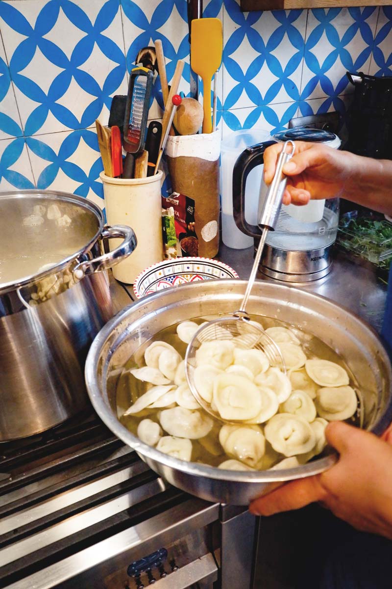 removing the cooked pierogies from the boiling water