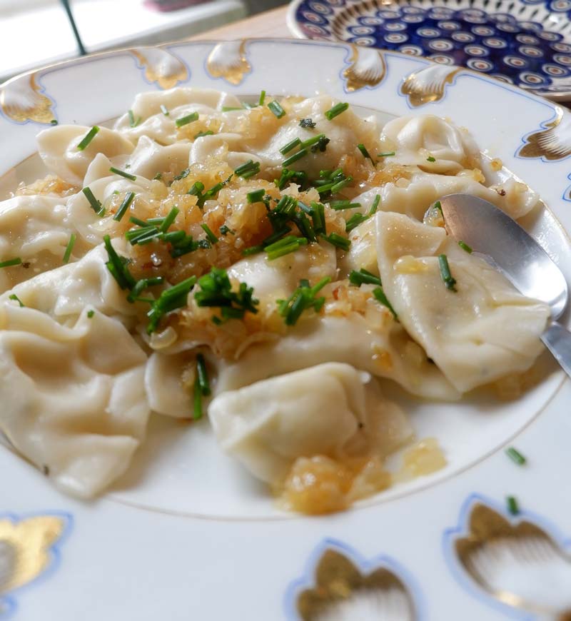 serving the dumplings on a plate with the frid onion on top